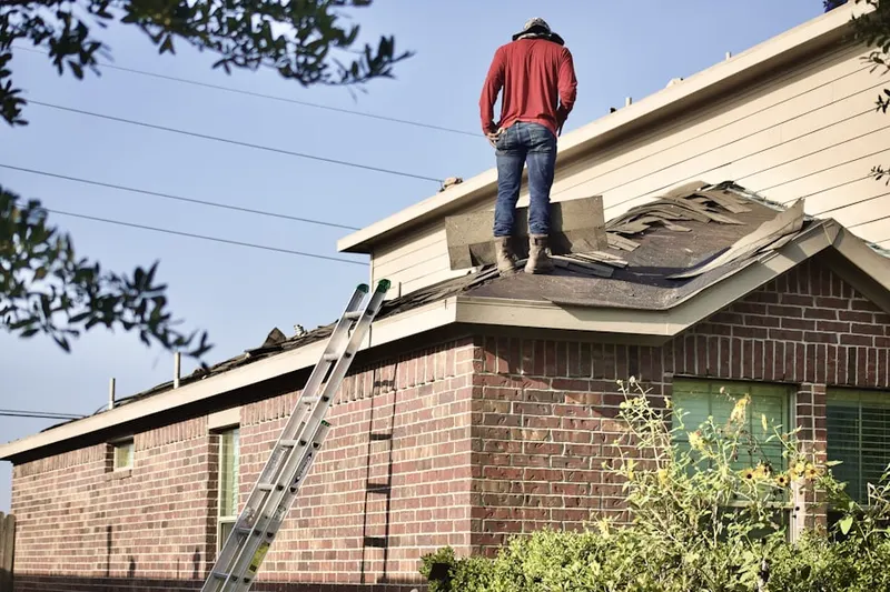 Professional roofer working on a residential roof in Fiedler